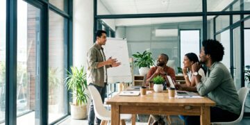 A leader telling a story to engaged colleagues in a bright modern meeting room
