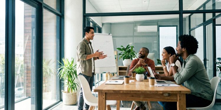 A leader telling a story to engaged colleagues in a bright modern meeting room