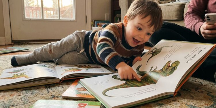 A child excitedly reading dinosaur picture books at home