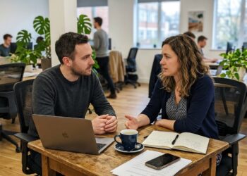 Two colleagues having a direct, honest conversation at a desk